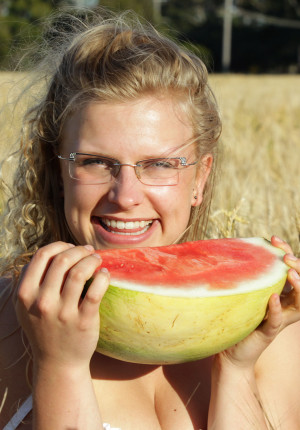 Cute Australian blonde Gretel has fun eating a watermelon in the nude in a field